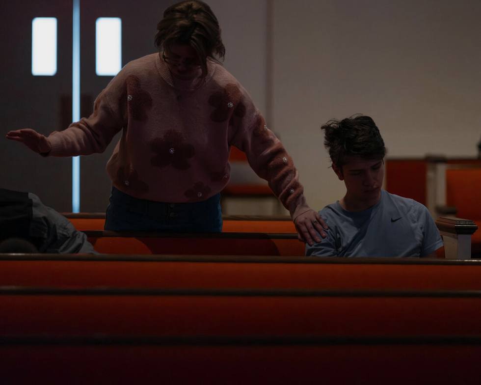 Praying over a student in the pews