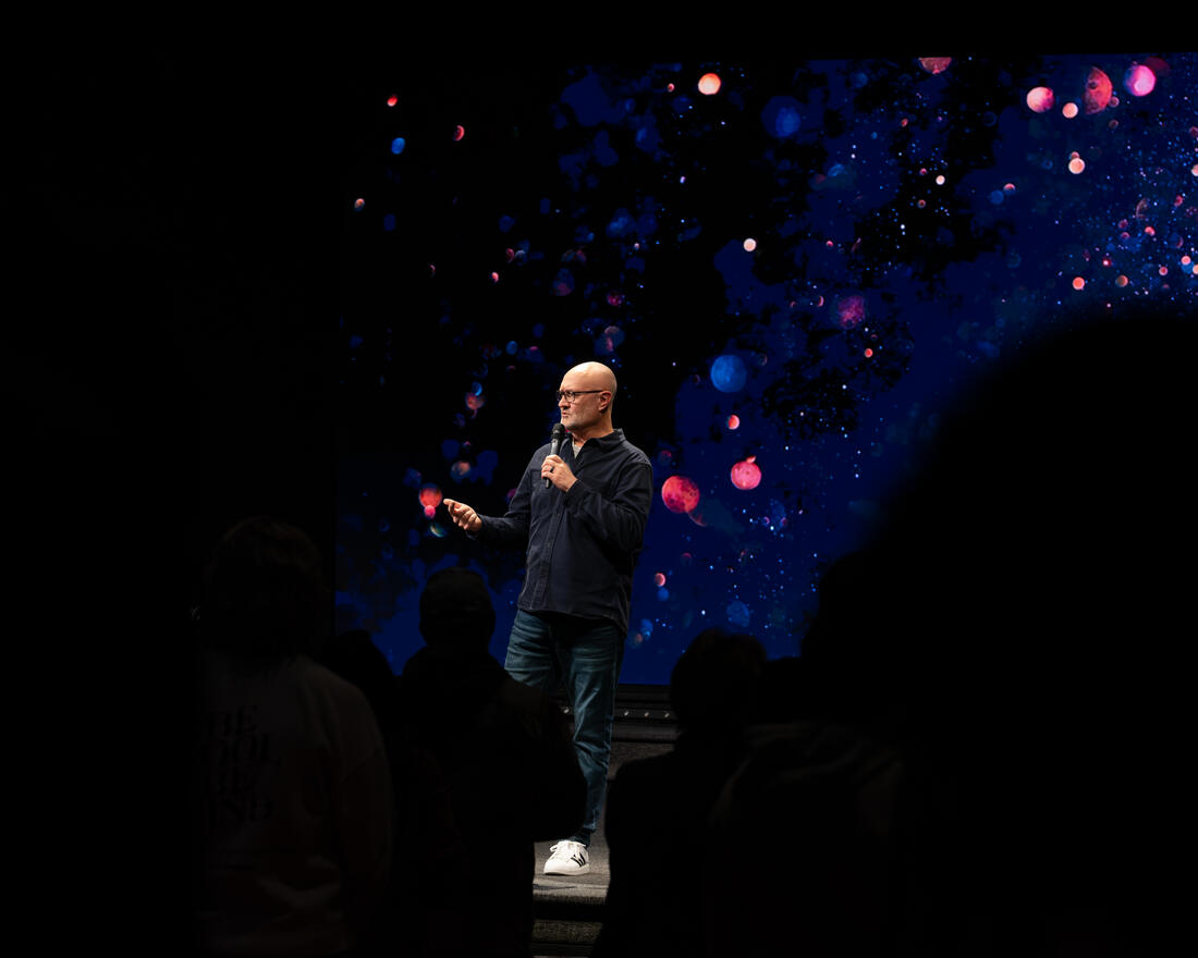 A pastor speaking under the stage lights